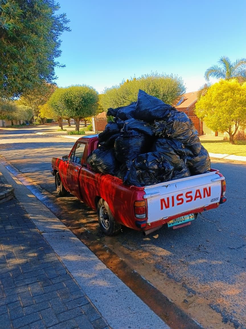 MoveFlex bakkie loaded with black refuse bags at golden hour on a suburban street