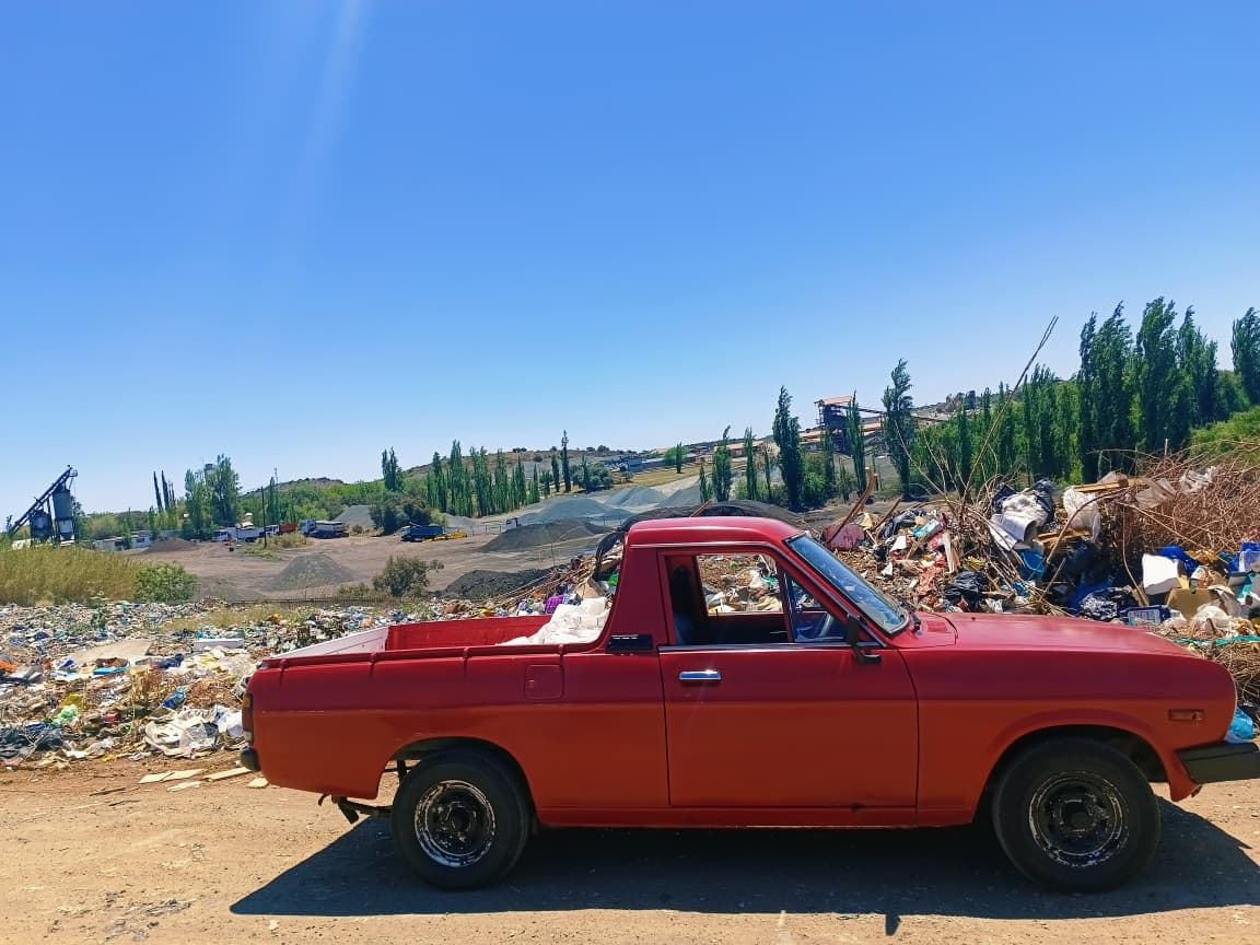 MoveFlex bakkie parked at the landfill site with dumping grounds visible in the background