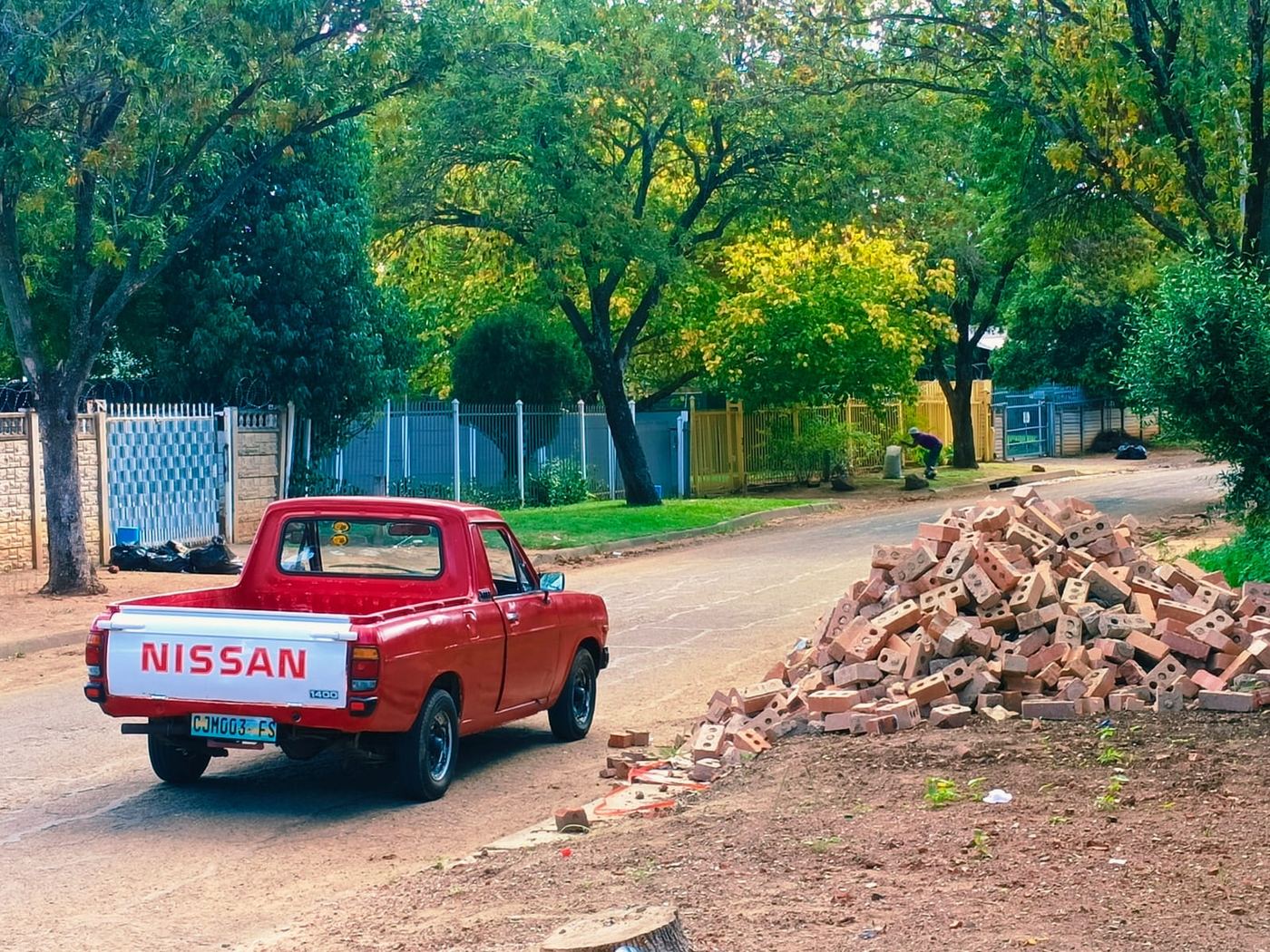 MoveFlex bakkie parked beside a large pile of broken bricks and rubble ready for removal